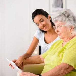 Young woman assisting older lady with technology