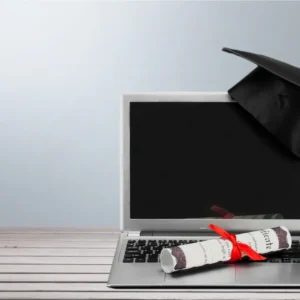 Graduation cap on laptop with diploma