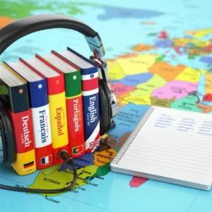 Multilingual books and headphones on colorful map